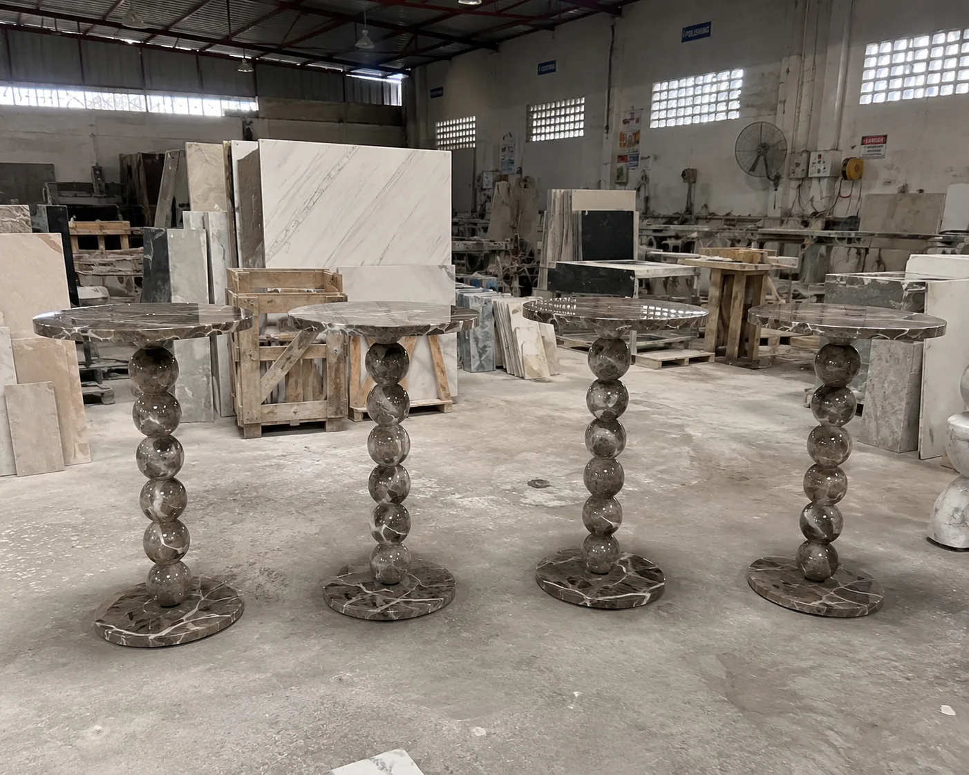Sculptural marble pedestal tables in the workshop